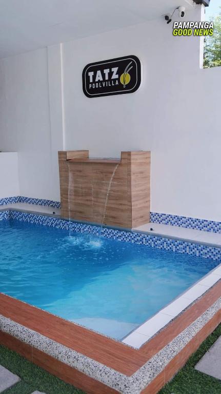 a pool in a building with a sign on the wall at Tatz Pool Villa in Anunas