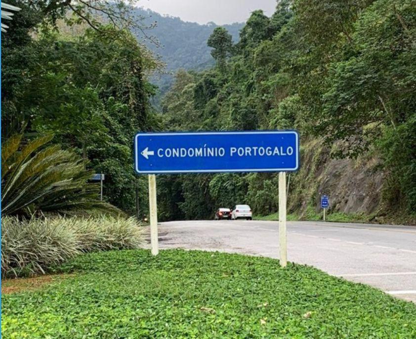 a blue street sign on the side of a road at Suíte 3 Vila dos Pescadores Condomínio Portogalo in Angra dos Reis