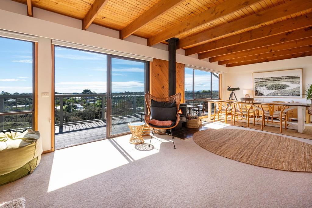 Koonya Treetops with Cedar Spa في بليرغوري: غرفة معيشة بها موقد وطاولة وكراسي