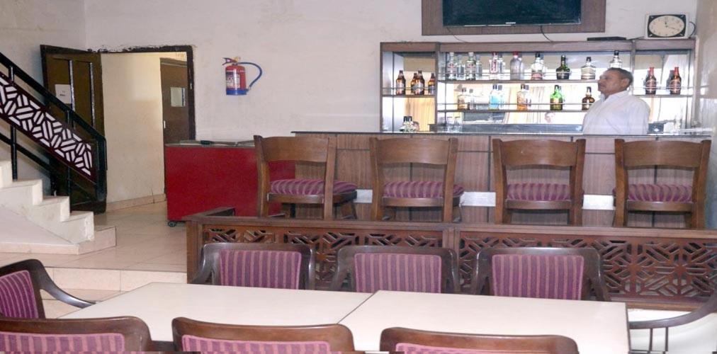 JīndBulbul Tourist Resort的站在餐厅酒吧的男人