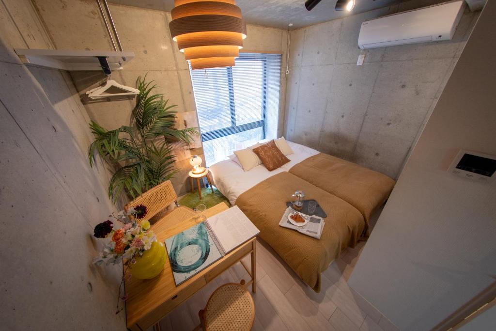 a small room with a bed and a table with a table at Ueno Grand Maison Hotel in Tokyo