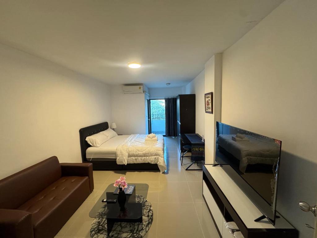 a living room with a couch and a bed at Natthapimon in Bangkok Yai