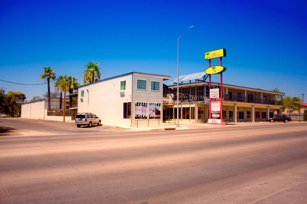 een gebouw aan de kant van een weg met een straatbord bij Whispering Palms Inn in Del Rio