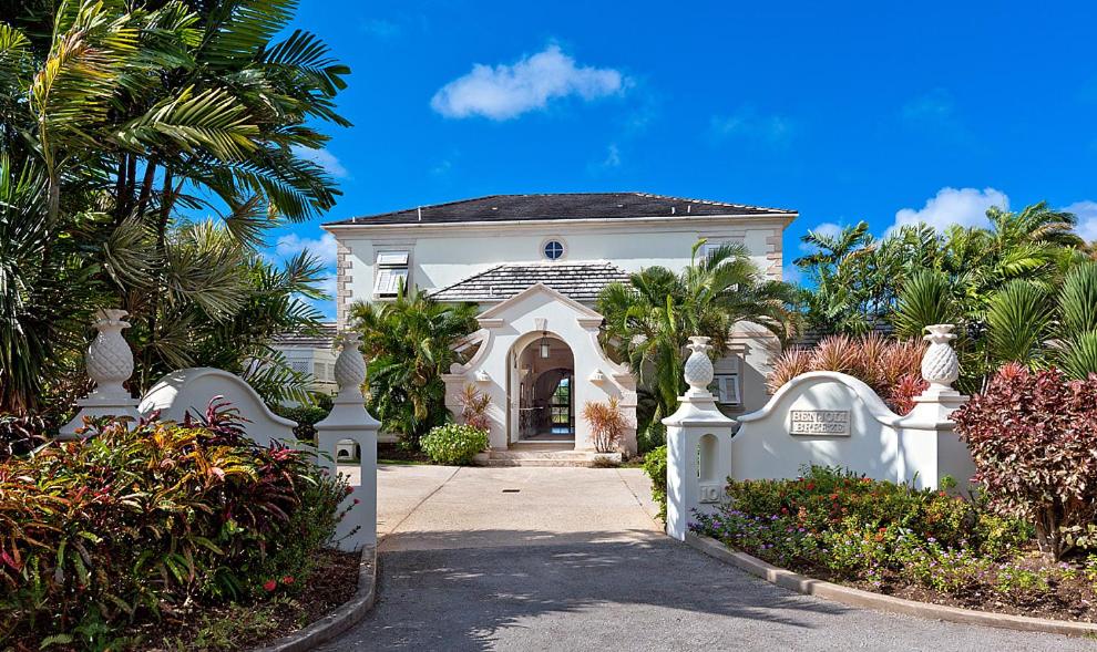 a white house with a gate and palm trees at Royal Westmoreland Benjoli Breeze, Palm Ridge 10 by Island Villas in Saint James