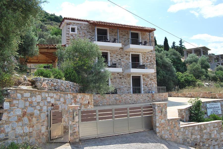 a stone house with a garage in front of it at Labetia Apartments in Agioi Apostoli