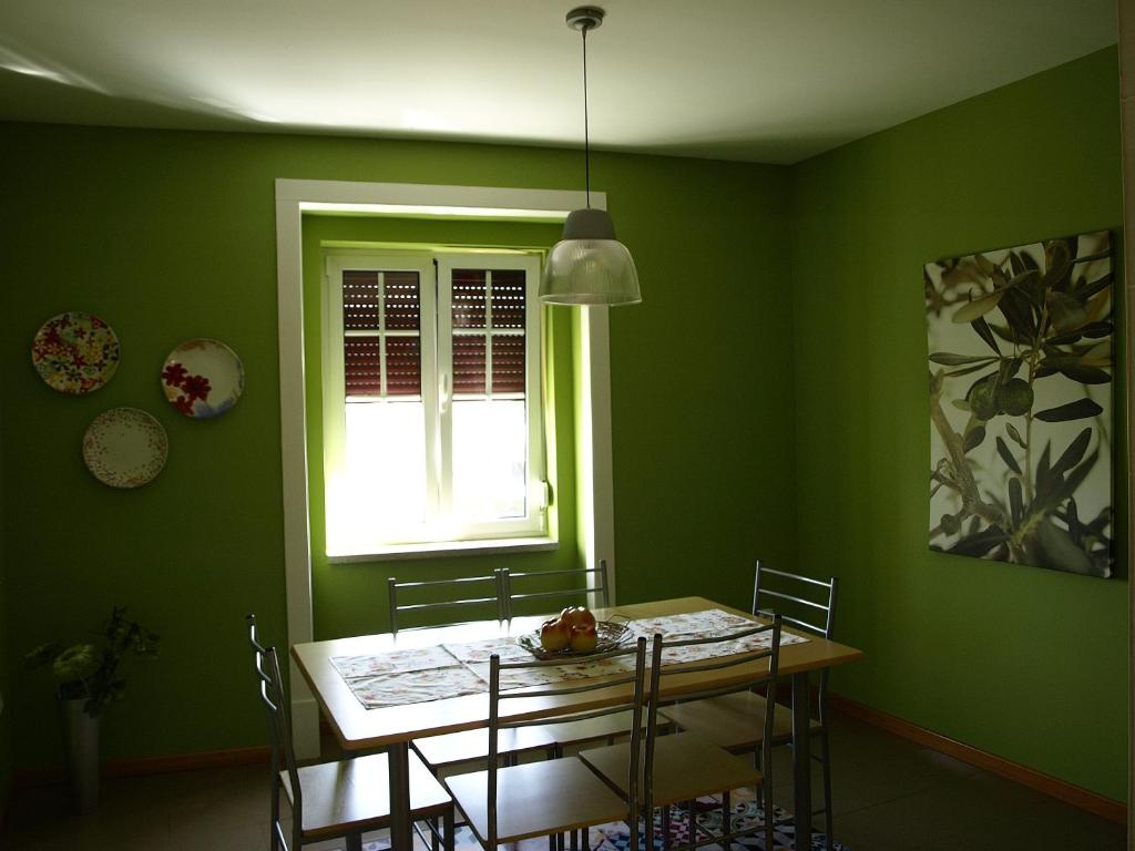 une salle à manger verte avec une table et une fenêtre dans l'établissement Casa da Fonte Nova, à Coja