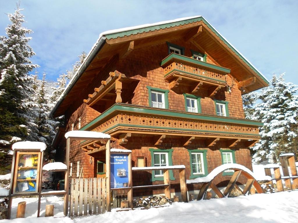 a large wooden house in the snow with snow at Ferienwohnung Trattenhaus in Krimml