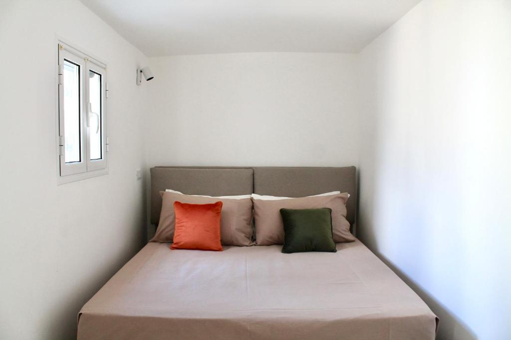 a bed in a room with four pillows at CASSIODORO - Home & Terrace in Ostuni