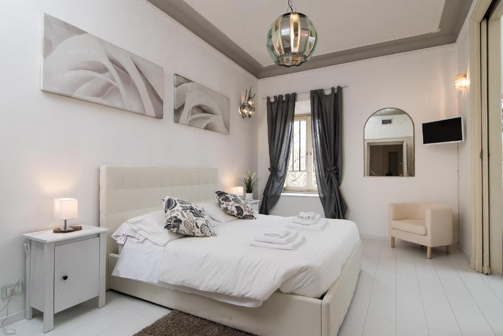 una camera bianca con letto e specchio di White Borgo Apartment a Roma