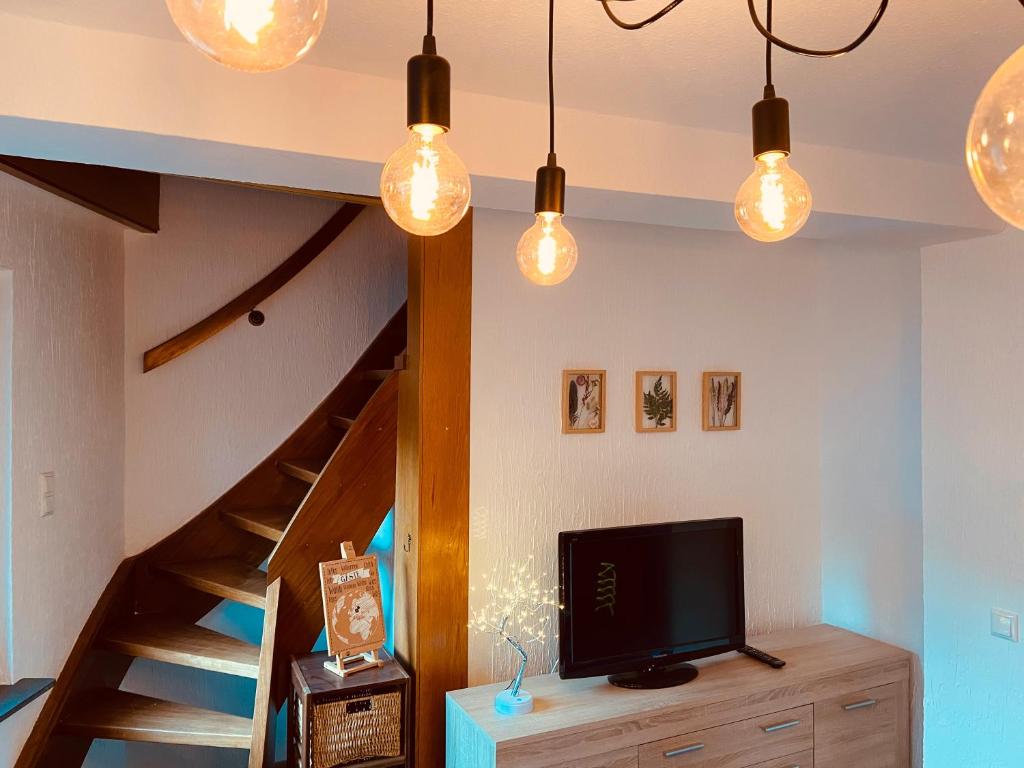 ein Wohnzimmer mit einem TV und einer Treppe in der Unterkunft Ferienhaus Sötenicher Mühle in Kall