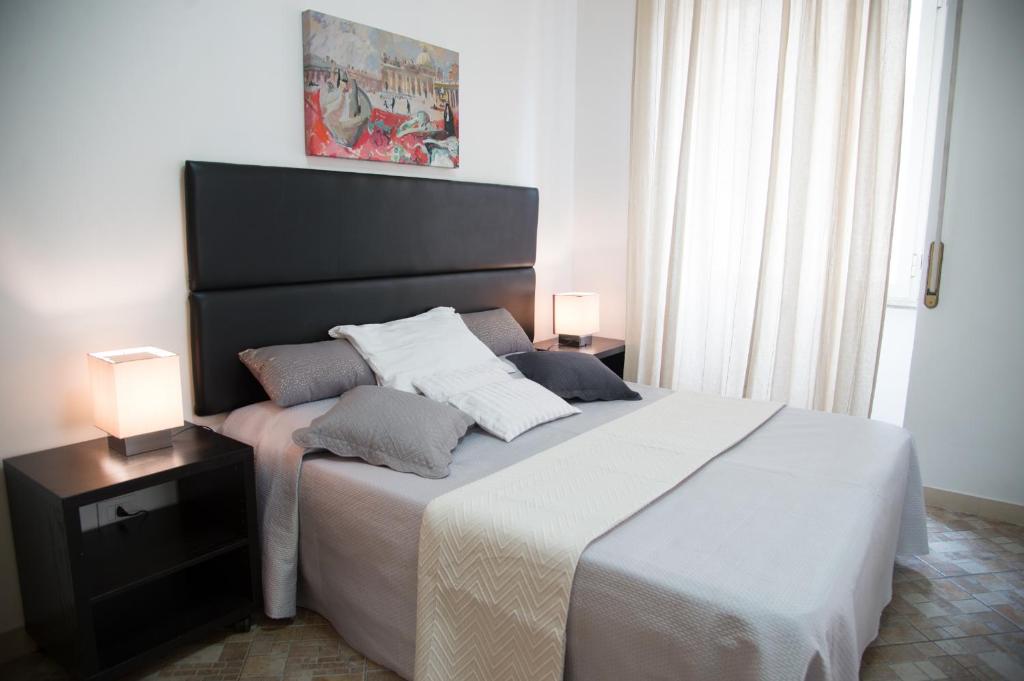 1 dormitorio con 1 cama grande y 2 lámparas. en Casa Alberone, en Roma