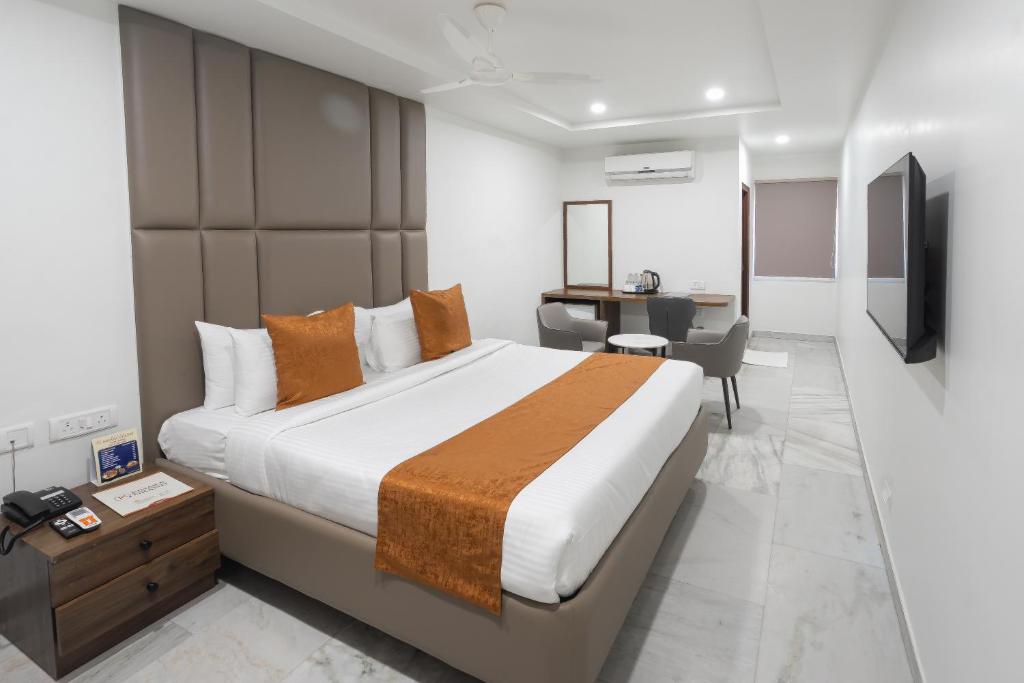 海得拉巴Hotel Kinara Grand的一间带大床和书桌的卧室