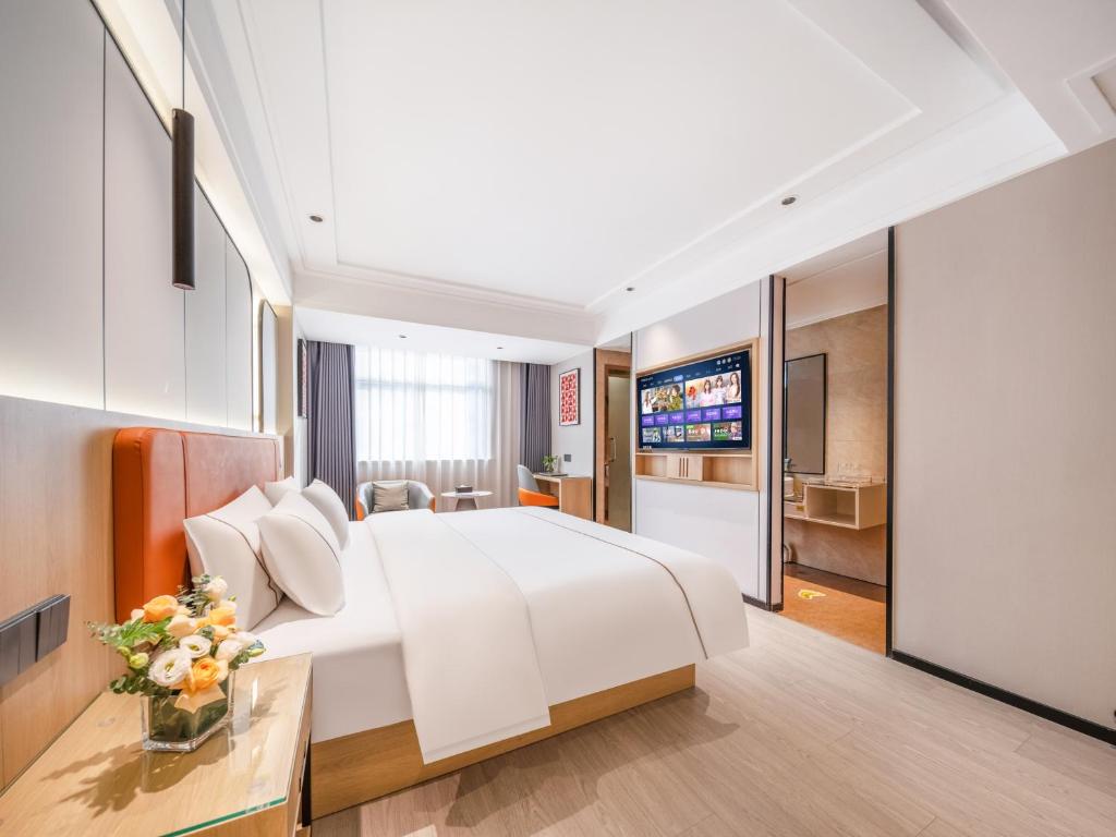 a hotel room with a large bed and a television at Yiwu Yunjing Hotel in Yiwu