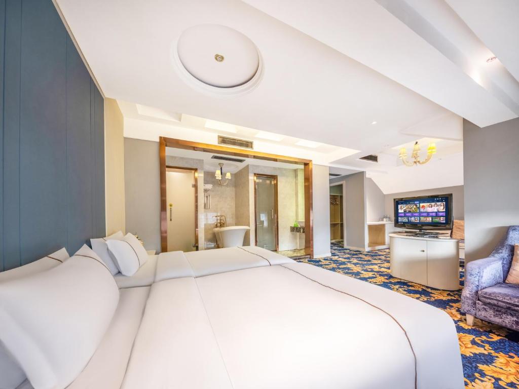 a hotel room with a large bed and a television at Yiwu Yunjing Hotel in Yiwu