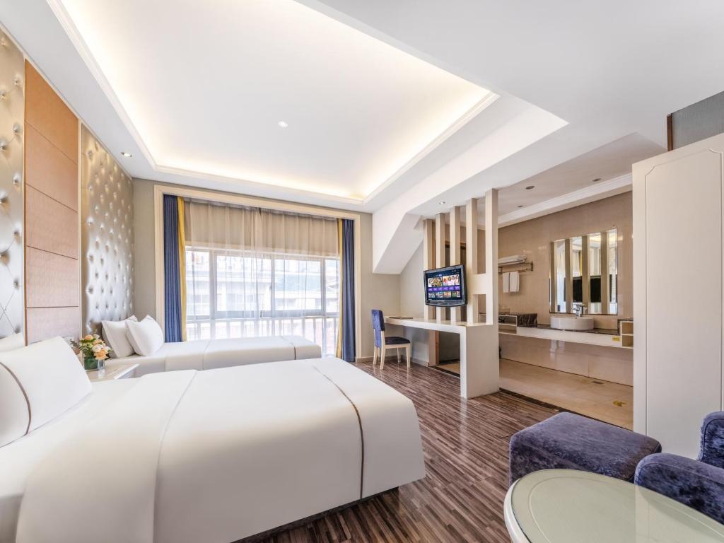a hotel room with a large bed and a kitchen at Yiwu Yunjing Hotel in Yiwu