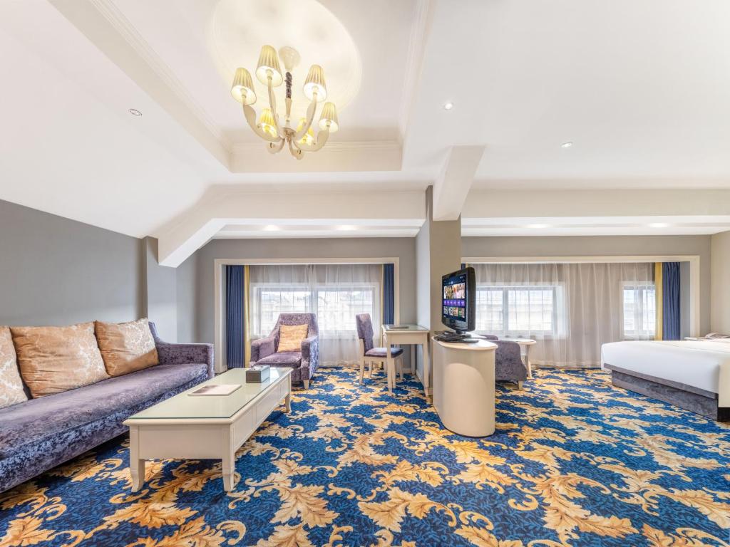 a hotel room with a couch and a bed at Yiwu Yunjing Hotel in Yiwu