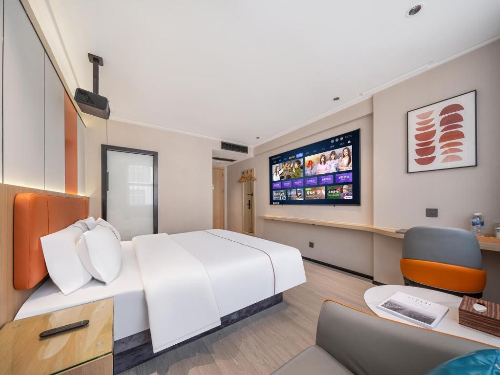 a hotel room with a bed and a tv at Yiwu Yunjing Hotel in Yiwu