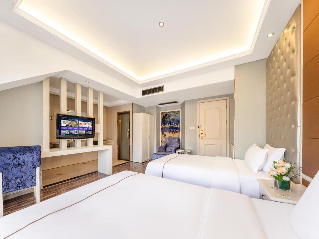 a hotel room with two beds and a television at Yiwu Yunjing Hotel in Yiwu