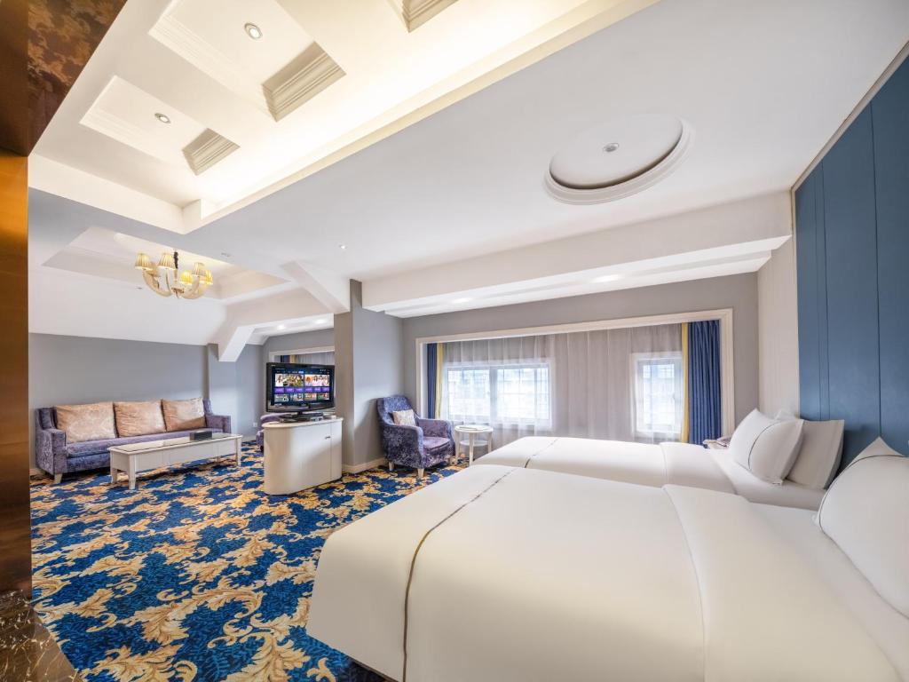 a hotel room with a large bed and a television at Yiwu Yunjing Hotel in Yiwu
