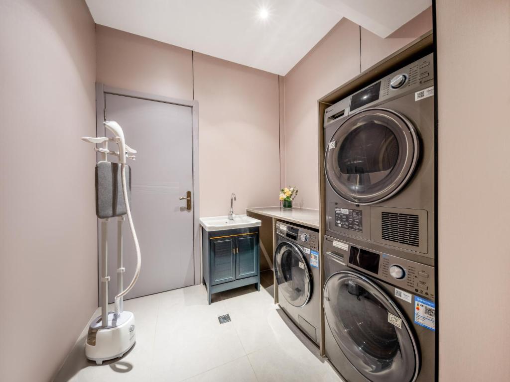 a laundry room with two washing machines and a sink at Yiwu Yunjing Hotel in Yiwu