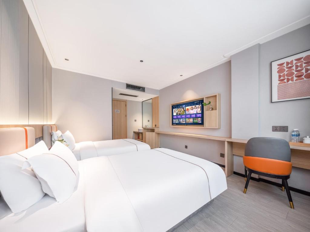 a hotel room with two beds and a television at Yiwu Yunjing Hotel in Yiwu