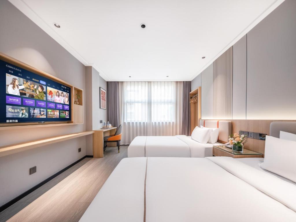 a hotel room with two beds and a flat screen tv at Yiwu Yunjing Hotel in Yiwu
