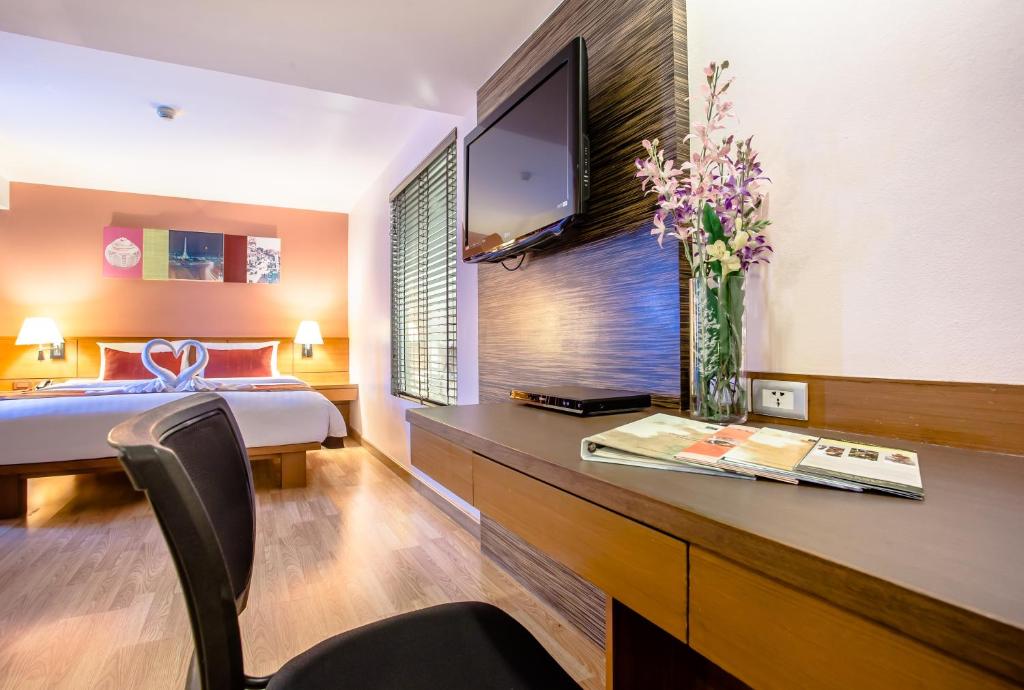 A guestroom workspace facing the bed and television wall.