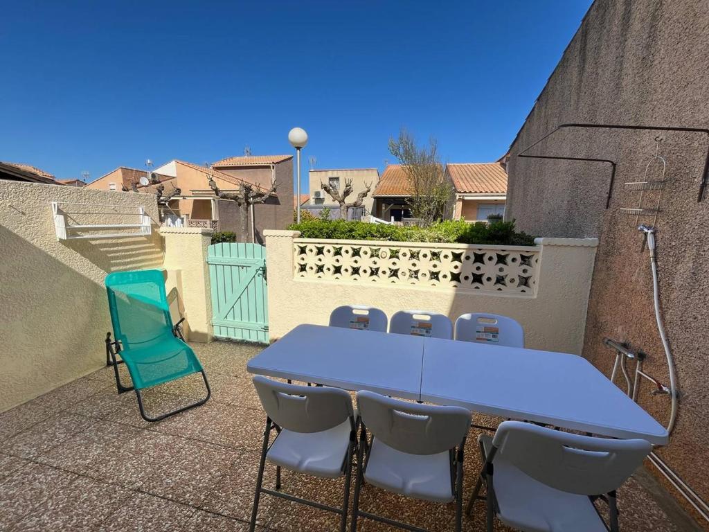 une table et des chaises bleues sur une terrasse dans l'établissement Maison de vacances 6 couchages, 2 chambres, mezzanine, wifi, 100m de la plage residence VILLAGE MER LRVM26, à Portiragnes