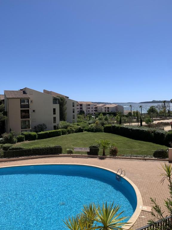 une grande piscine devant un immeuble dans l'établissement Appartement Domaine de la Coudouliere dont piscine de mai à septembre, à Six-Fours-les-Plages