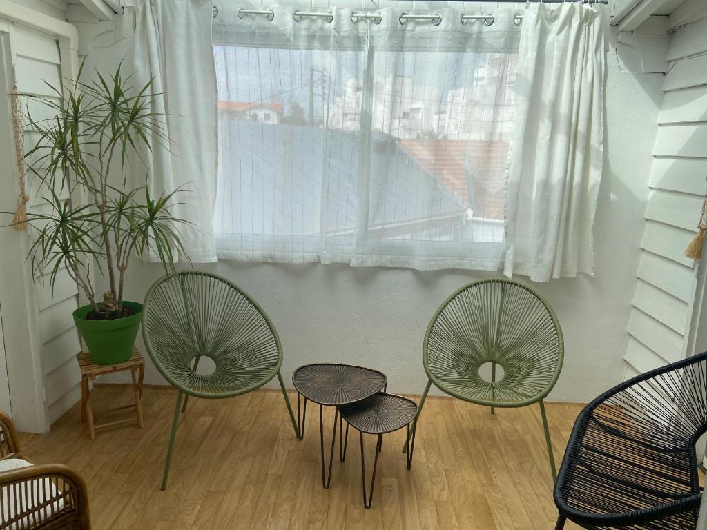 3 chaises et une table devant une fenêtre dans l'établissement L'Eden, à Arcachon