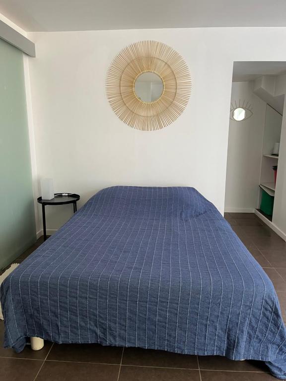 une chambre avec un lit bleu et un miroir dans l'établissement Joli studio cosy, à Marseille