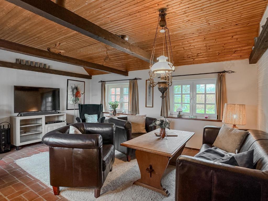 a living room with leather furniture and a wooden ceiling at Haus Küstersmatt am Deich - Minsen in Minsen