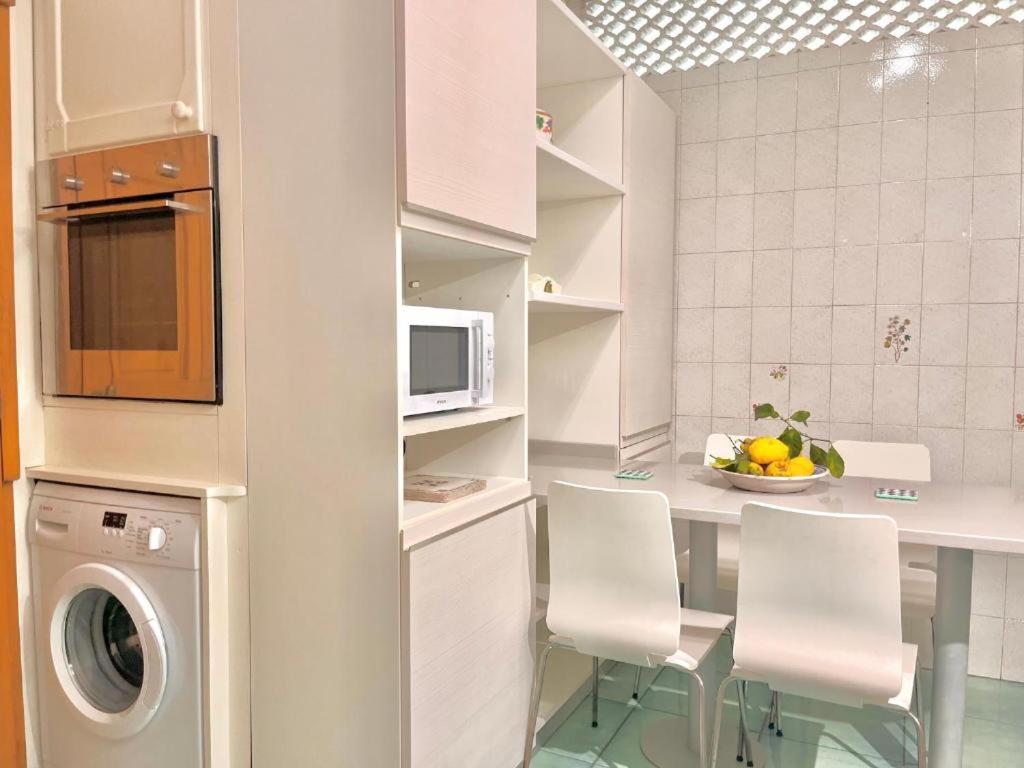 a kitchen with a table and chairs and a microwave at Large family appartament with pool in Sorrento