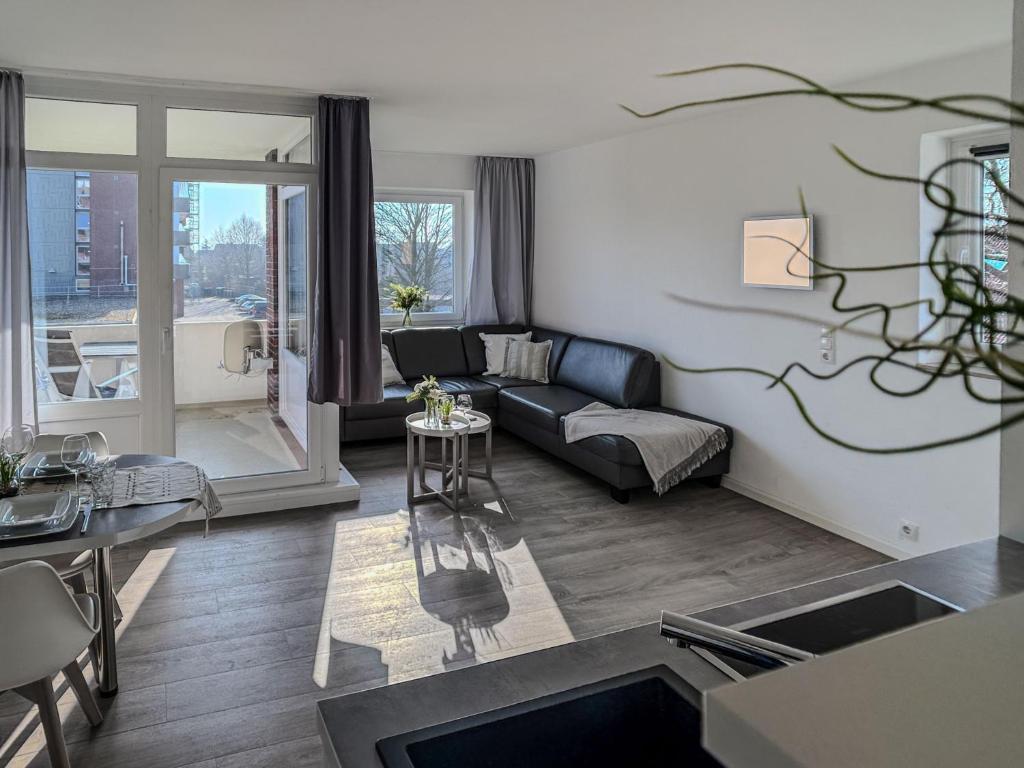 a living room with a couch and a table at FeWo Friesenkoje - Horumersiel in Horumersiel