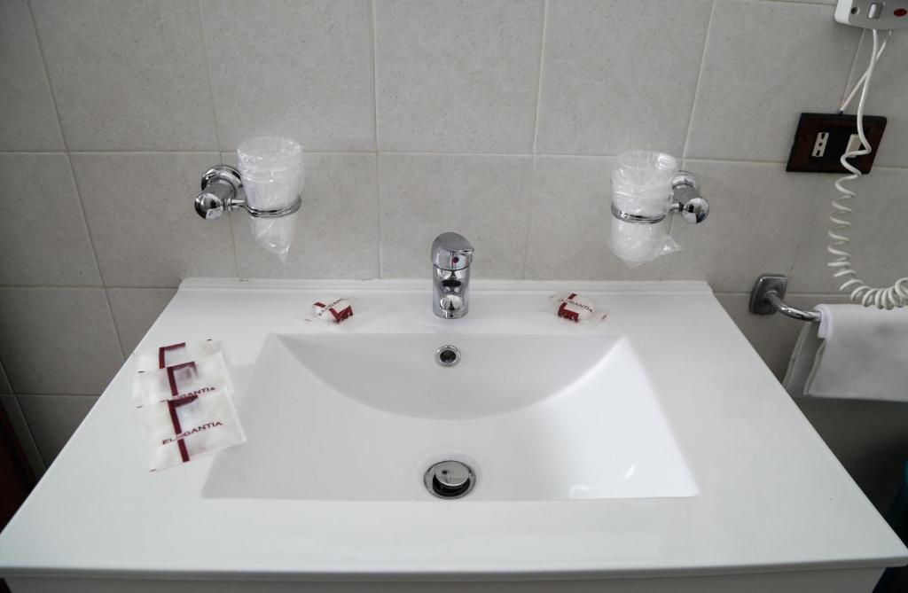 a white bathroom sink with christmas bows on it at Roma Room Hotel in Rome
