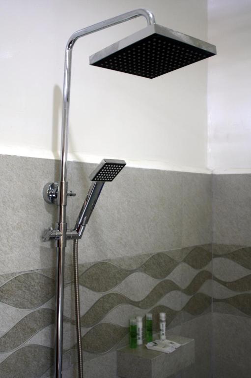a shower with a shower head in a bathroom at The Magic Sponge in Kampot