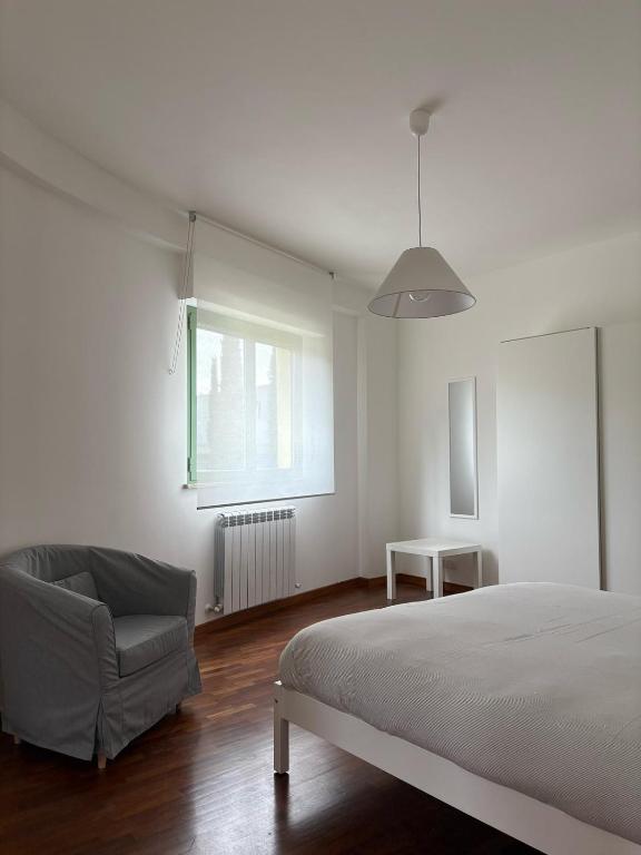 a bedroom with a bed and a chair and a window at Fontana Apartment 2 in Perugia