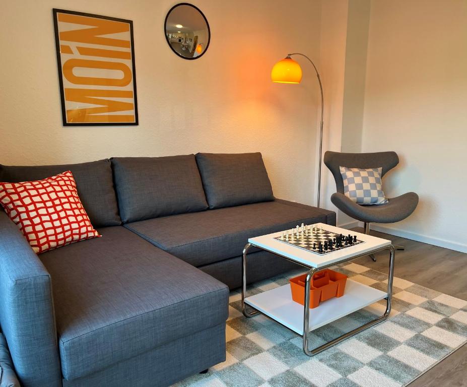 a living room with a couch and a chessboard on a table at NEU 2025 - Fewo mit Meerblick & Flair in Harrislee