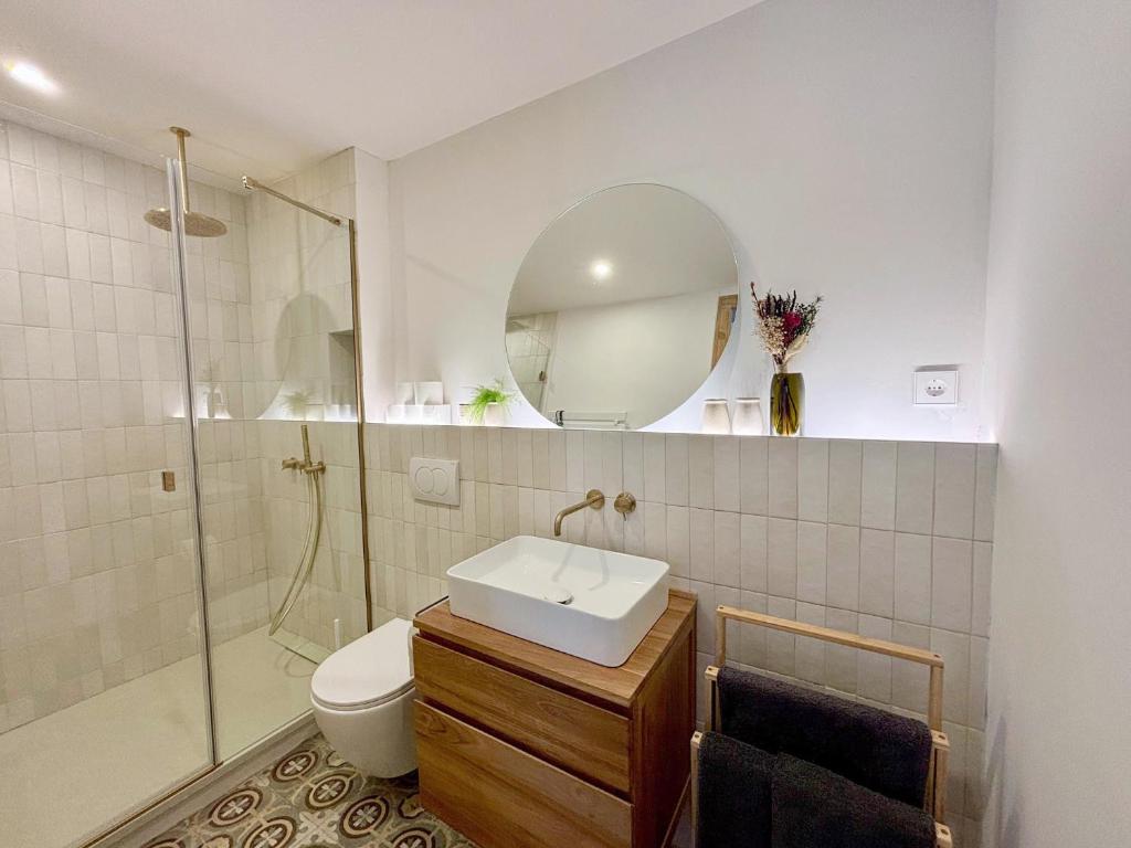 ein Badezimmer mit Toilette, Waschbecken und Spiegel in der Unterkunft Cozy Suite in a historic house near the sea in Vilanova i la Geltrú