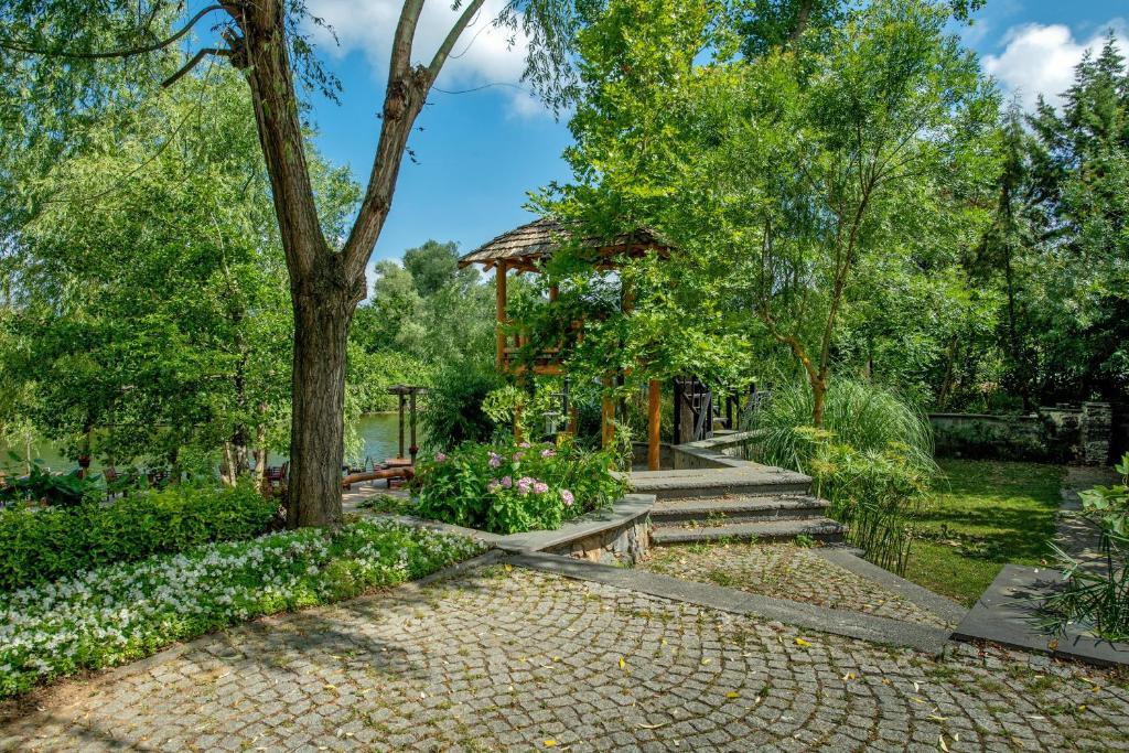 a garden with a gazebo and flowers at Wineport Lodge Agva Riverside Hotel & Winery in Ağva