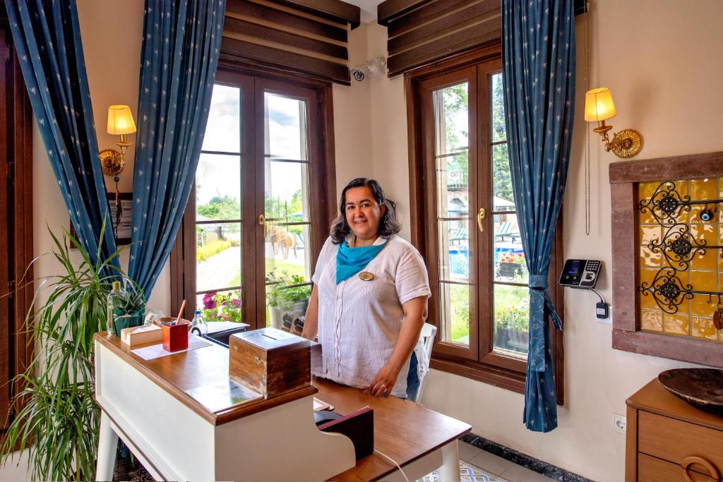 a woman standing in a room with a desk at Wineport Lodge Agva Riverside Hotel & Winery in Ağva