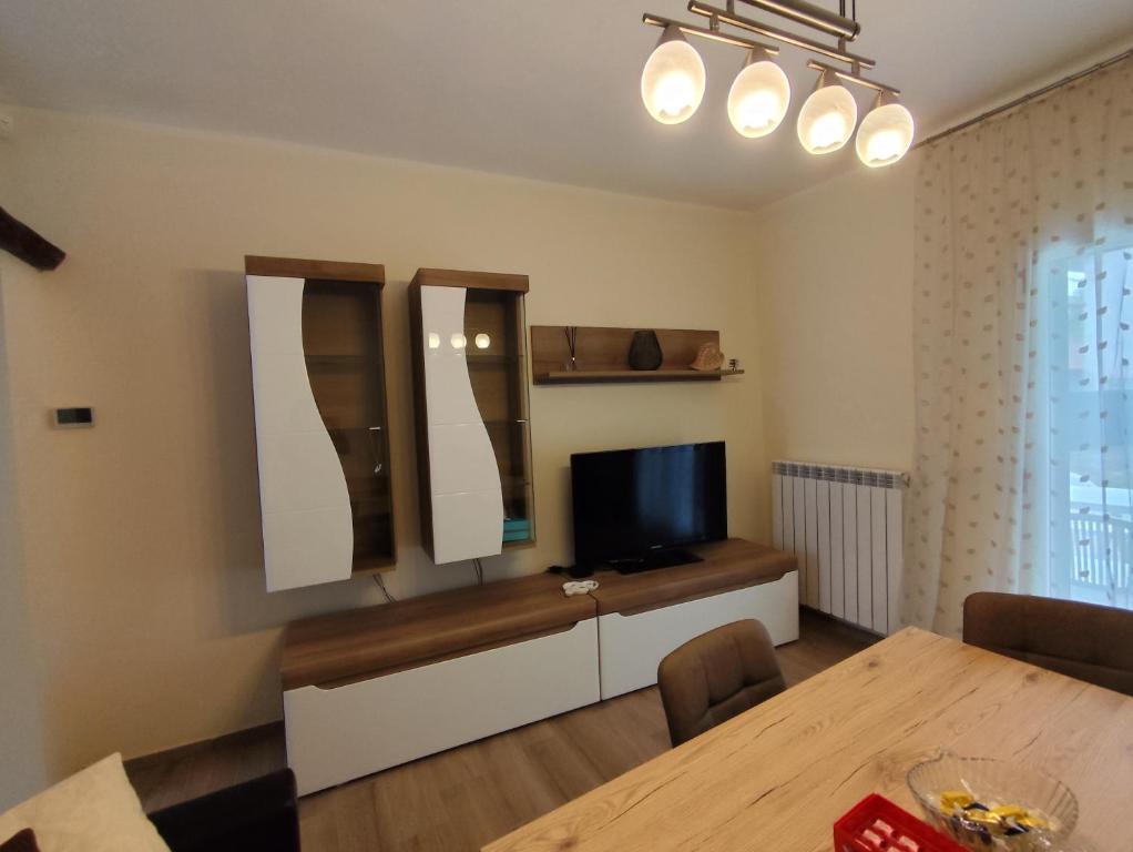 a living room with a table and a television at Casa Milona in Castelveccana