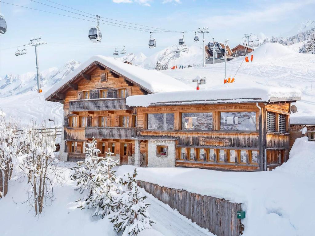 a log cabin in the snow with a ski lift at Chalet 5★, 15 pers, pied des pistes, spa extérieur, 7 chambres - FR-1-304-308 in La Clusaz