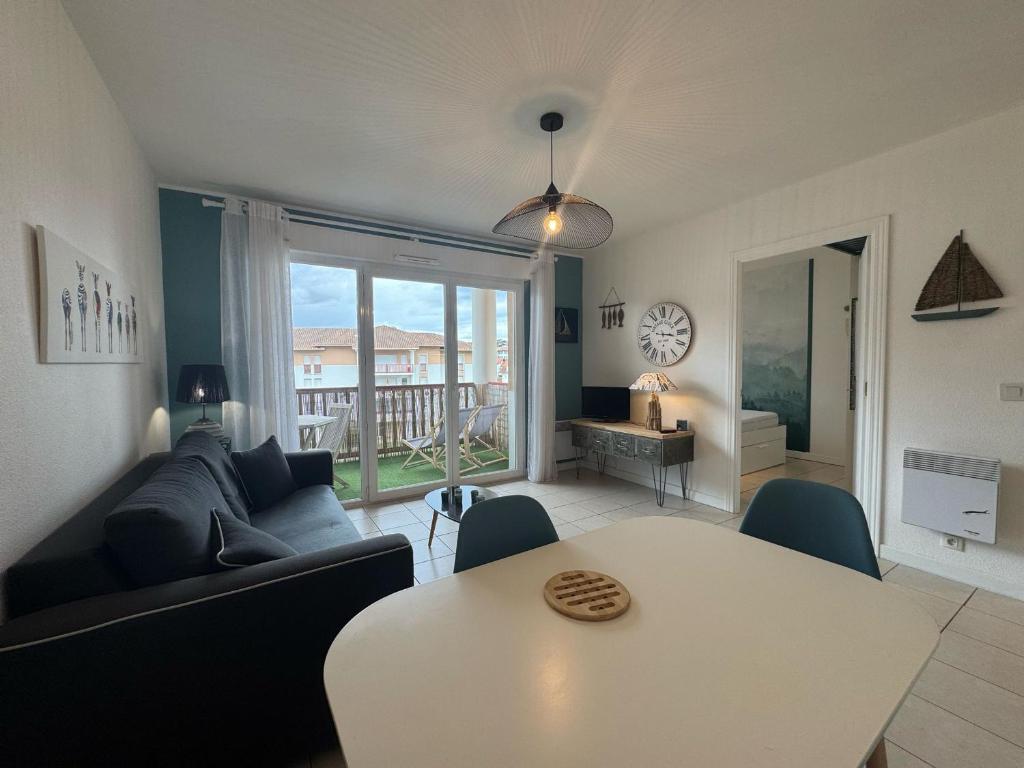 a living room with a couch and a table at Charmant T2 rénové avec terrasse proche plage - FR-1-239-1106 in Ciboure