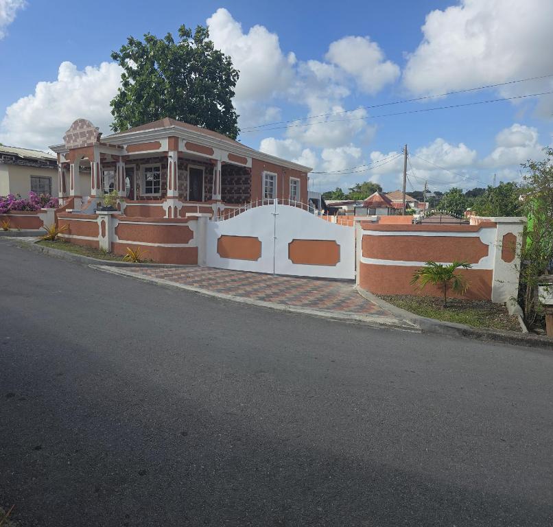 a house with a white fence on the side of the road at Historic Manor in Bridgetown