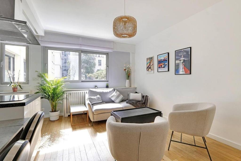 un salon avec un canapé et une table dans l'établissement Appartement spacieux - Arc de Triomphe, à Paris