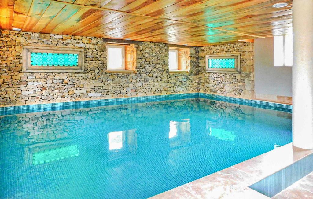- une piscine dans une maison dotée d'un mur en pierre dans l'établissement Awesome Home In La Chapelle-Aubareil, à La Chapelle-Aubareil