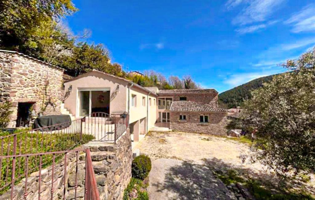 une maison avec un mur en pierre et une allée dans l'établissement Pittoresque Maison De Vacances, à Rochesadoule
