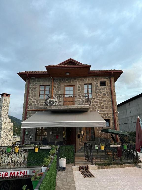 a building with a balcony on top of it at Bahçeli Taş Villa in Trabzon