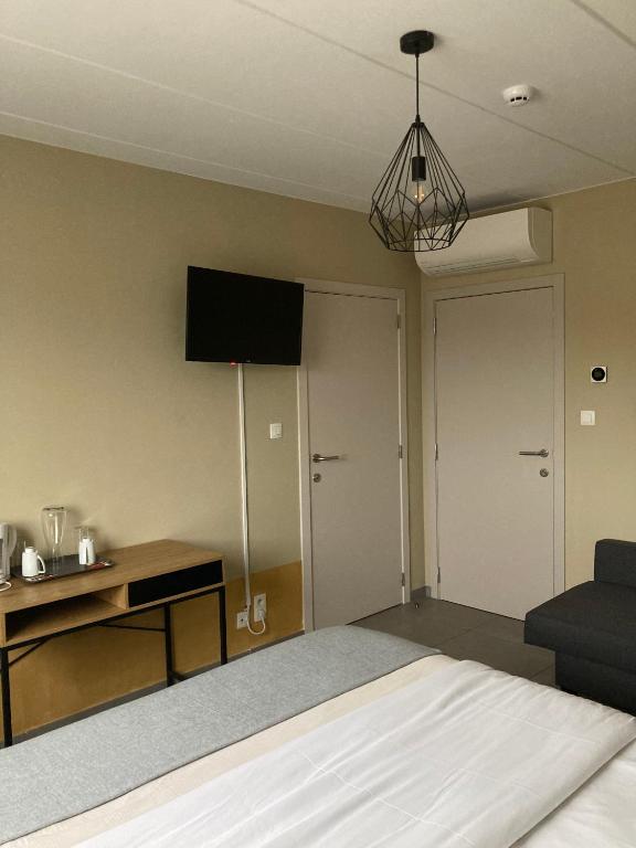 a room with a bed and a tv on the wall at Côté Grange in Tournai